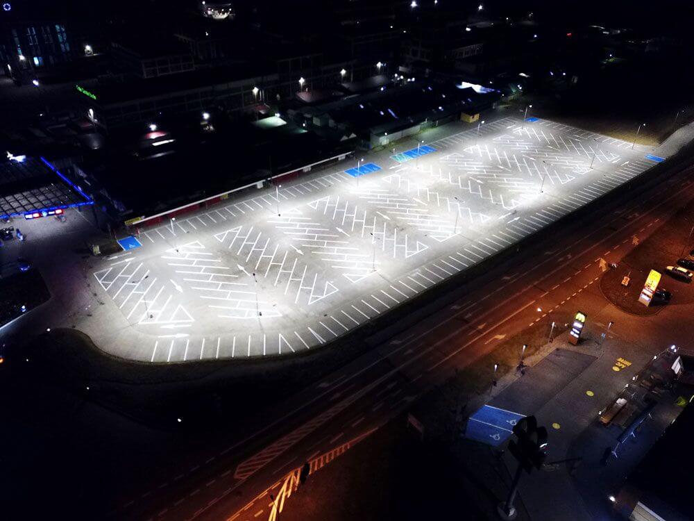 Luftaufnahme der lückenlos ausgeleuchteten Parkflächen am Polenmarkt Hohenwutzen bei Nacht durch AML-SL2 LED-Straßenlaternen.
