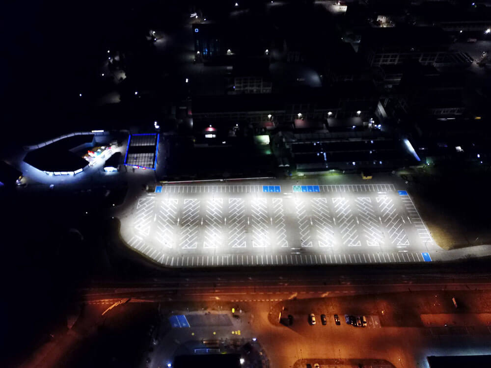 Luftaufnahme bei Nacht: Gleichmäßige und großflächige LED Parkplatzbeleuchtung am Polenmarkt Hohenwutzen.
