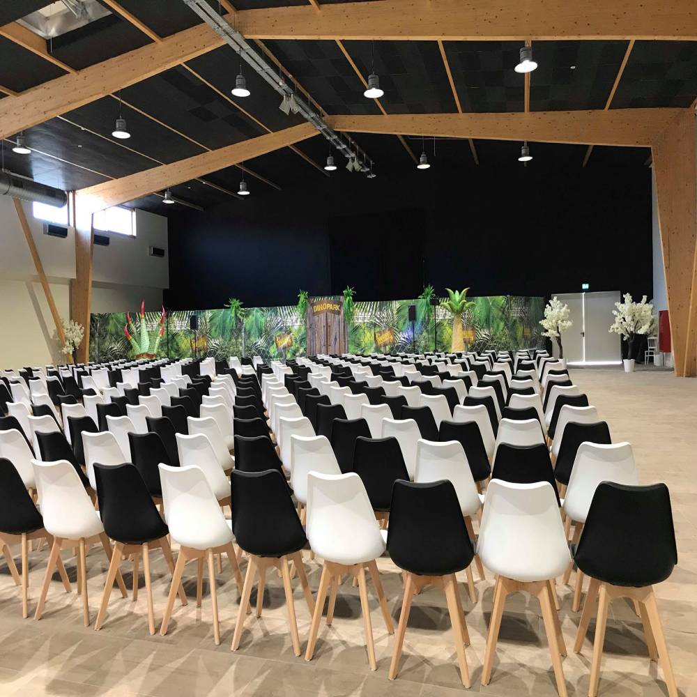 Großer Veranstaltungsraum in einem Eventzentrum, beleuchtet durch unauffällige LED-Hallenstrahler, die ein angenehmes und variables Lichtambiente erzeugen.