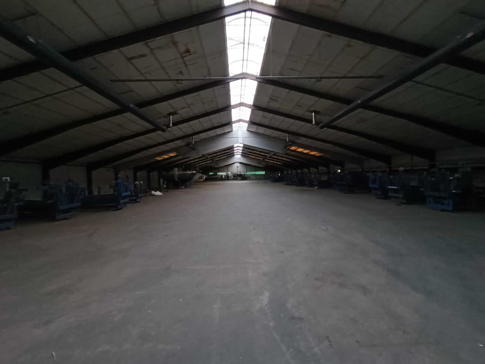 Referenz Sporthafen Kiel 3 Dunkle, leere Lagerhalle am Sporthafen Kiel ohne eingeschaltete Beleuchtung, was die Notwendigkeit der LED-Nachrüstung verdeutlicht.