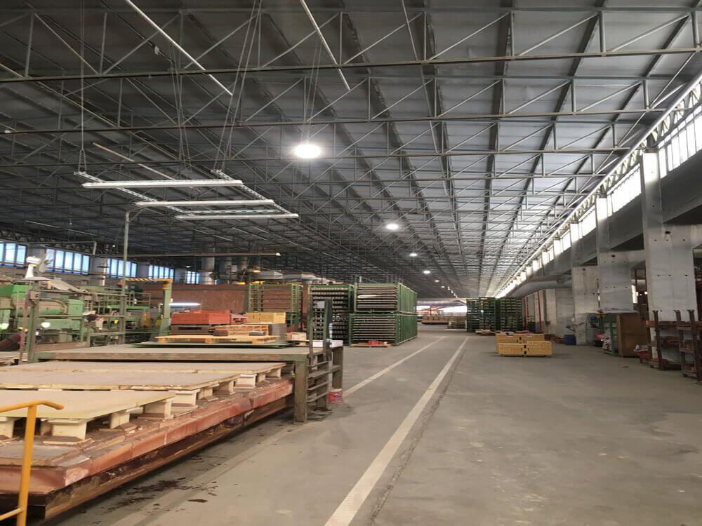 Helle und sichere Laufwege in der Produktionshalle dank moderner LED Industriebeleuchtung.